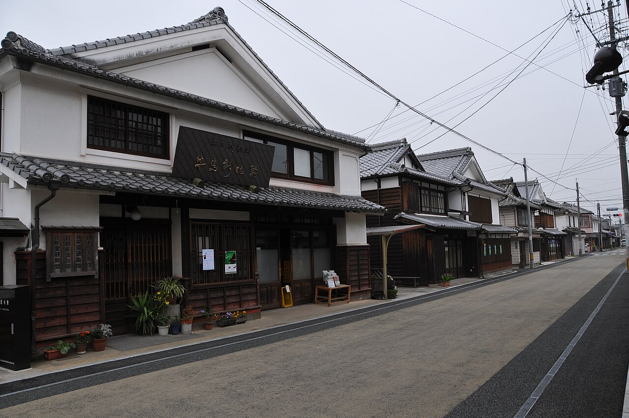 A street lined with old merchant houses with white plaster walls, dark timber lattices and tiled roofs, in the Fukushima district of Yame