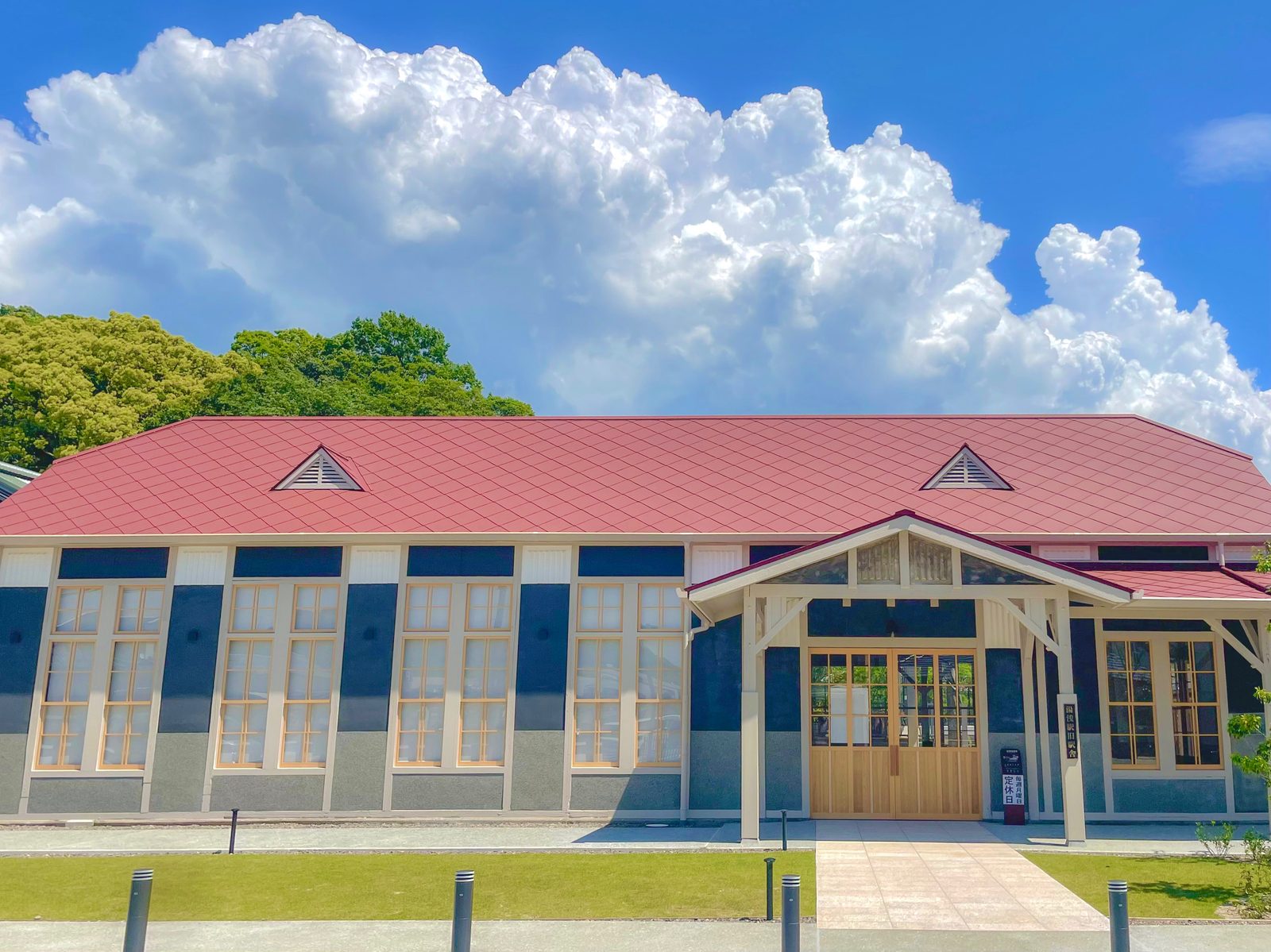 Old Yuasa Station building with a red-tiled roof, white walls and blue-grey shuttered windows