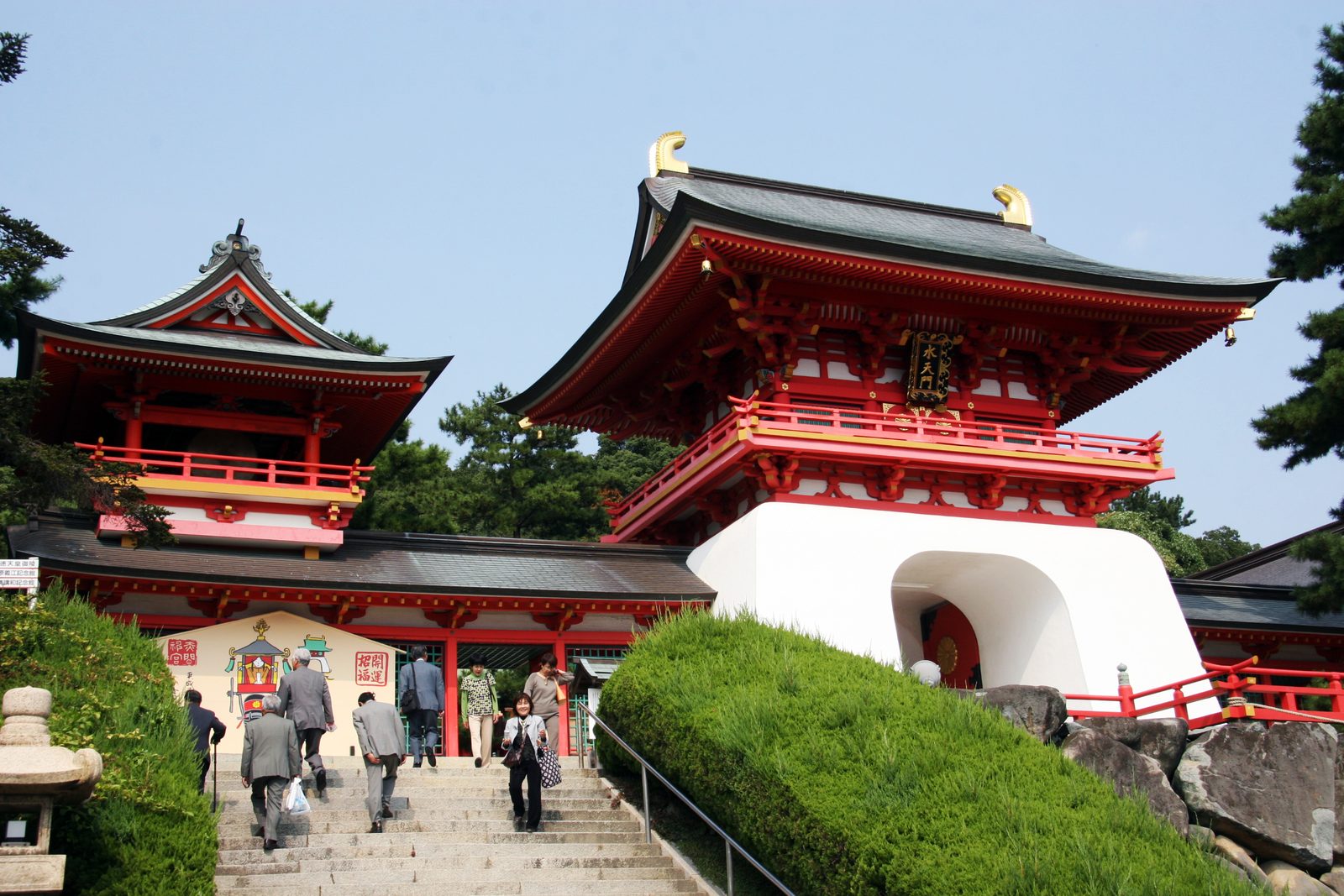 The red and white dragon-palace style gate of Akama Shrine above a stone stairway