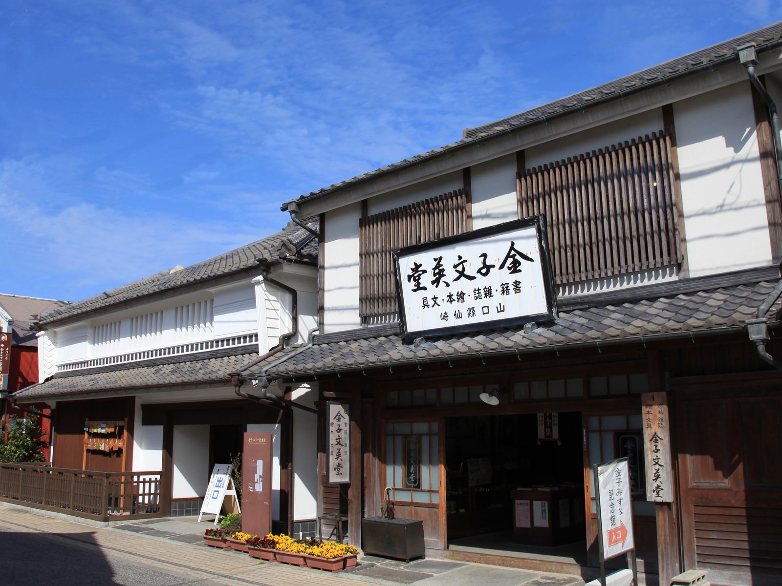 Traditional two-story building with white plaster walls and wooden lattice windows near the Kaneko Misuzu Memorial Hall in Senzaki, Nagato